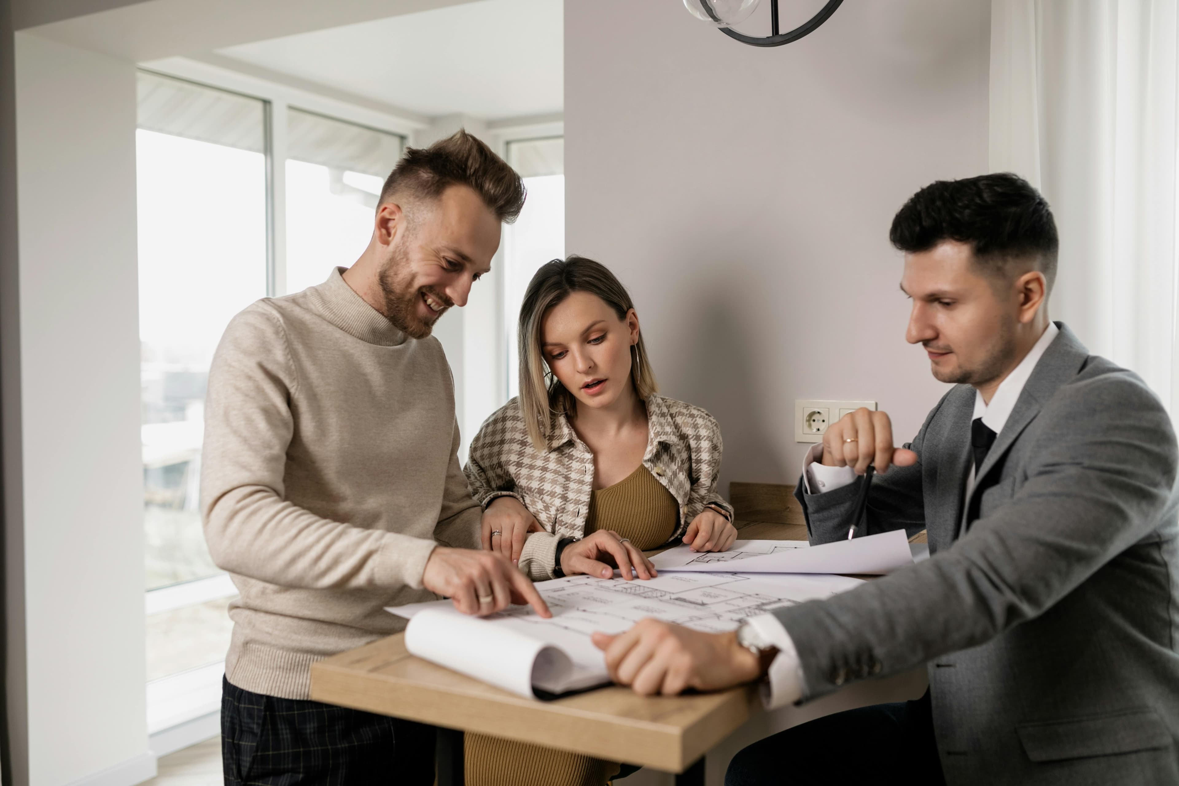 Homebuyers reviewing plans with natural light flooding the living room.